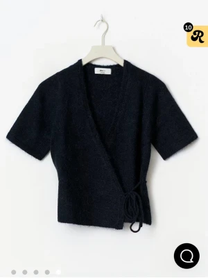 Marinblå omlottkofta från Gina Tricot - Säljer en marinblå omlottkofta från Gina Tricot med korta ärmar och knyt i sidan. Aldrig använd.