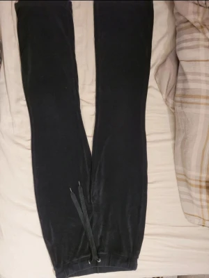 Svarta mjukisbyxor i sammet - Mysiga svarta mjukisbyxor i mjuk sammet med resår och snörning i midjan. Perfekta för chill dagar hemma eller när du vill ha det extra bekvämt. Klassisk passform och stilrena detaljer.