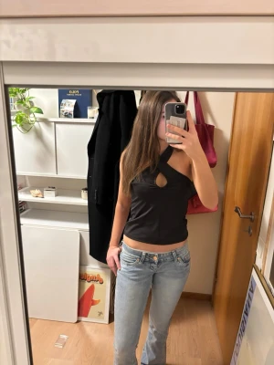 Svart topp från Vero Moda - Säljer en svart halterneck topp från Vero Moda med snygg cut-out framtill. Toppen är ärmlös och har en tight passform. Helt ny med prislapp!