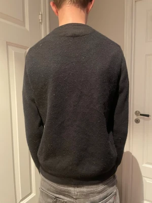 Svart ulltröja från Ralph Lauren - Säljer en svart tröja från Polo Ralph Lauren i mjuk ull. Klassisk rund halsringning och diskret gul broderad logga på bröstet. Lite för liten för mig för den är för den här krypt lite på mig i tvätten så den är en M men känns som en S