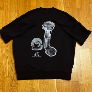 Armani Sweater - Snygg svart sweatshirt från Armani Exchange med unikt silvertryck. Loose fit, passar även Medium. Sparsamt använd och i superbra skick, inga skador.