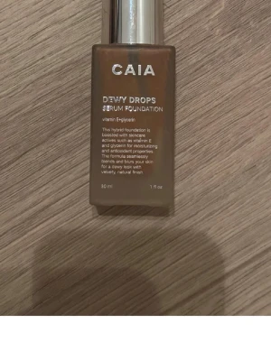 CAIA Dewy Drops Serum Foundation - Foundation från CAIA i nyansen Dewy Drops. Kommer i en snygg glasflaska med silverfärgad pump. Innehåller vitamin E och glycerin för återfuktning och ger en naturlig, daggig finish. Perfekt för dig som vill ha en fräsch och glowig look.