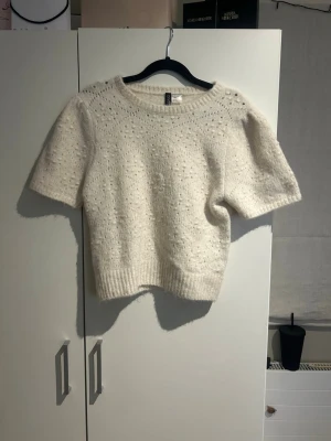 Vit stickad kortärmad tröja H&M - Mysig vit stickad tröja från H&M med korta ärmar och rund hals. Jätte fin med prislapp kvar ordinarie pris 299kr i storleken S💗