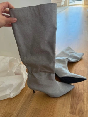 Glittriga silverfärgade stövlar - Helt nya klackskor från Zara. Nyttpris: 700 Mitt pris: 400 Storlek 39