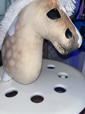 Beige käpphäst med vita detaljer - Säljer en superfin käpphäst i beige med vita fläckar och vit man. Det ingår lite utrustning till 