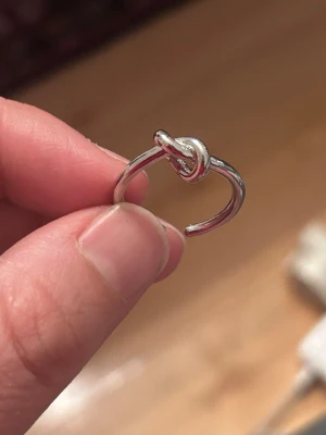 Ring Knut design  - Snygg och stilren ring i stål med dekorativ knut framtill. Enkel men unik design som passar både till vardag och fest. Ringen är öppen baktill vilket gör att den kan justeras något i storlek. ✔ Material: Stål ✔ Färg: Silver ✔ Skick: Mycket fint