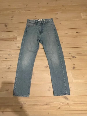 Blå relaxed jeans från Jack & Jones - Säljer ett par ljusblå jeans från Jack & Jones, modell Chris. Klassisk femficksdesign, raka ben och normal midja. Passformen är neutral. Materialet är tålig denim i bomull. Bara att höra av sig vid frågor.