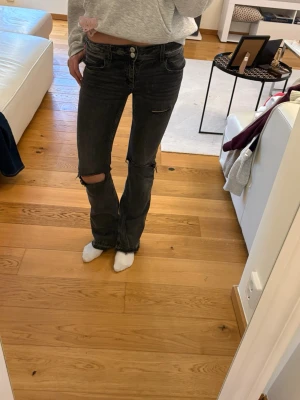 Svarta bootcut jeans med slitningar - Säljer mina jättefina gråa bootcut jeans från Gina i storlek 164, har sprättat upp de längst ner och klippt hål i de själv så säljer de därför för endast 150☺️