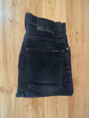 Nudie Jeans - Säljer ett par svarta bootcut jeans från Nudie Jeans, modell boot ben. Midja 32cm, längd 96cm. Obs jeansen har en fläck på baksida lår. JAG SKICKAR EJ FLER BILDER NÄR JAG BÄR JEANSEN! för bättre inblick i passformen rekommenderar jag att googla på modellnamnet. För storleksguide kolla måtten noggrant då jeansen alltid kan vara uppsydda heller krympta och jag ej tar emot returer :) s6,1