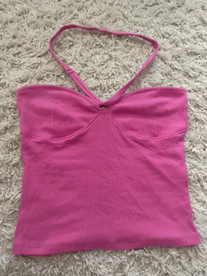 Halterneck topp - Jätte fin rosa halterneck topp från ginatricot i storlek S💗 Säljer då den inte kommer till användning, den är i jätte fint skick och använd 1 gång💗 Den har silikon band runt sig så den inte glider av!