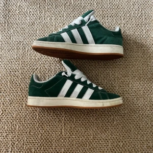 Adidas campus  - Säljer ett par gröna adidas campus i ett väldigt bra skick. Dessa skor har inga skador, men mindre smutsfläckar förekommer. Snören och box ingår. Originalpris: 2400. Hör av er vid eventuella frågor, allt gott!