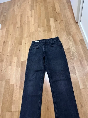 Mörkblå raka jeans från Zara - Snygga mörkblå jeans från Zara med rak passform och klassisk femficksdesign. Jeansen har hög midja och är tillverkade i ett slitstarkt denimtyg. Perfekta för en trendig och avslappnad look.