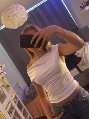 Vit offshoulder topp🤍 - Säljer en vit offshoulder topp med croppad passform. Toppen har en snygg asymmetrisk axelbandslös design och sitter tight mot kroppen. Perfekt för dig som vill ha en enkel men trendig look till jeans eller kjol.