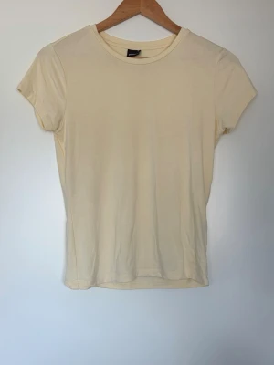 Gul T-shirt  - Fin tight T-shirt från Gina tricot. Endast använd vid några få tillfällen.