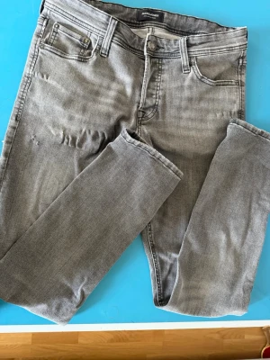 Jack & Jones slim fit jeans - Gråa slim fit jeans med egna slitningar riktigt feta jeans. Perfekt inför hösten som kommer.