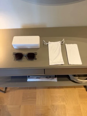 Grå solglasögon från CHIMI - Säljer ett par stilrena solglasögon från CHIMI med transparent grå båge och fyrkantig form. Kommer med originaletui och tygpåse. Perfekta för att lyfta din look med en modern touch.