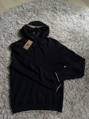 Mörkblå Boggi Milano hoodie - Boggi Milano hoodie i storlek S. Mörkblå med vita detaljer. Använd max 5 gånger och mycket fint skick (9,5/10). Inga hål, fläckar eller andra defekter!