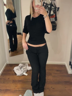 Svarta kostymbyxor med låg midja - Snygga svarta kostymbyxor från bikbok med låg midja och raka ben. Byxorna har en klassisk passform och stilren look. säljer då dom blivit för tajta! helt nya 