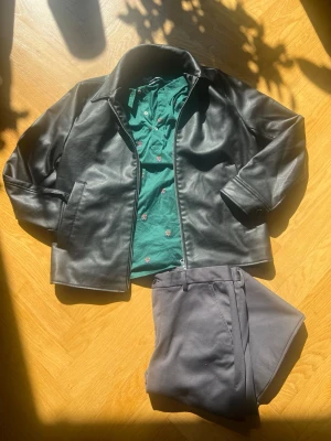 Färdig outfit, skinnjacka, Ralph lauren piké, kostymbyxor - En snygg outfit, skinnjacka från h&m, jackan har lite riv märken på olika ställen, men ser fortfarande snyggt ut. (Se sista bilderna) STL M Mörkgrön piké från Ralph lauren. STL M Kostym byxor grå jack&jones. STL  L.                        Tveka inte att fråga något. Obs! Inga förhandlingar 