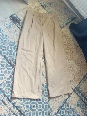 Beige kostymbyxor - Snygga beige kostymbyxor med vida ben. 