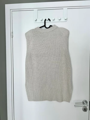 Stickad beige väst med markerade axlar från H&M - Markerade axlar och slits på båda sidor. Storlek S. Lite smånoppig men det tänker man inte så mycket på.   Kika gärna på mina andra annonser för bundle.