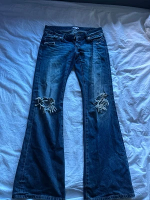 Lågmidjade bootcut jeans med hål - Såå snygga och bekväma jeans från gina tricot, de är lågmidjade och bootcut. Så snygg färg som passar perfekt till hösten, bra skick använda kanske 5 gånger
