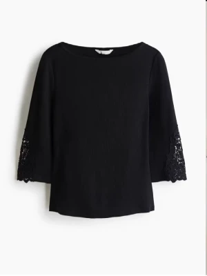 Svart topp med spetsdetaljer - Stilren svart topp med trekvartsärm och snygga spetsdetaljer längst ner på ärmarna. Rak passform och rund halsringning. Perfekt för dig som gillar en enkel men ändå elegant look.