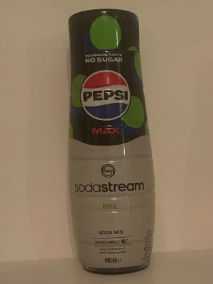 Sodastream Pepsi Max Lime Soda Mix - Säljer en Sodastream Pepsi Max Lime Soda Mix, 440 ml flaska. Smaksätt ditt bubbelvatten med lime och klassisk Pepsi Max utan socker. Flaskan är svart och vit med gröna detaljer och tydlig Pepsi-logga.