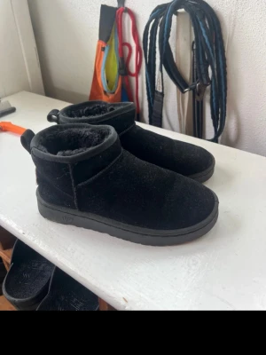 Svarta boots  - Mysiga fake uggs (den lägre modellen)  och mjukt, fluffigt foder på insidan. Utsidan är i mockaliknande material och sulan är i gummi. Perfekta för kalla dagar och till hösten.