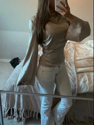 Boohoo beige satin topp  - Jättefin beige topp från Boohoo i ett glansigt, satinliknande material. Toppen har en feminin modell med ett fint fall och en elegant beige/champagnefärgad nyans.  Toppen är endast använd en gång och är därför i mycket fint skick.