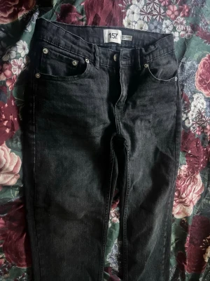 Svarta skinny jeans från 157 - Säljer ett par svarta skinny jeans från 157 med klassisk femficksdesign och silverfärgade nitar. Jeansen har normal midja och smal passform hela vägen ner. Perfekta för dig som gillar en enkel och stilren look.