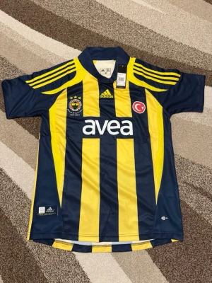 Fenerbahce 07-08 hemmatröja - Säljer Fenerbahce retro tröja från 07-08 säsongen. Den har Alex 10 där bak och är i Storlek M. Den är helt ny och perfekt för ett Fenerbahce fan.