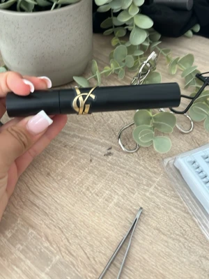 Grön ysl mascara med gulddetalj - Snygg grön mascara med elegant guldfärgad detalj på hylsan. Tuben har en matt finish och stilren design som känns lyxig och modern. Perfekt för dig som vill ha en mascara som både ser exklusiv ut och är enkel att använda.