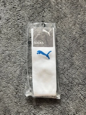 Vita fotbollsstrumpor från Puma - Vita långa fotbollsstrumpor från Puma. Tillverkade i ett stretchigt syntetmaterial som sitter skönt under träning eller match. Size 3/ storlek 39-42. Perfekta för dig som vill ha klassiska sportstrumpor med enkel design.