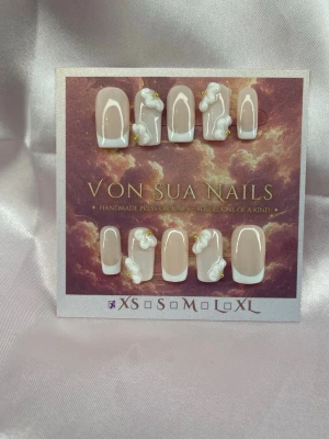 Amorette (XS);Short Square - Snygga handgjorda press-on naglar i fransk stil. Naglarna är nude med vit tipp och dekorerade med 3D-pärlor och små gulddetaljer. Formen är kort square och designen är handgjord för en unik look.XS: 14 mm, 11 mm, 11,5 mm, 10 mm, 8 mm