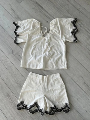 Vitt set med broderade kanter - Säljer ett oanvänd vitt tvådelat set från Vero moda i luftig bomull. Köpt från Australien för ca. 1100kr.Toppen är i storlek S och shortsen i storlek XS.
