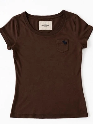 Brun t-shirt med ficka - Snygg brun t-shirt i bomull med liten bröstficka och diskret broderad logga. Klassisk rund halsringning och korta ärmar. Perfekt till jeans eller kjol för en enkel och stilren look.