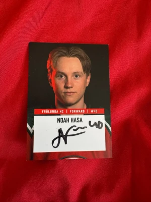 Signerad hockeykort Noah Hasa - Unikt hockeykort med Noah Hasa från Frölunda HC, forward #40. Kortet har en autograf på framsidan och spelarstatistik på baksidan. Designen går i rött, svart och vitt med klubbens logga och spelarinfo.
