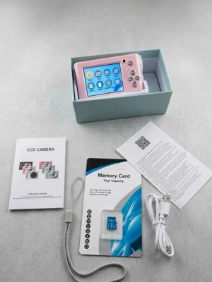 Rosa digitalkamera med tillbehör - Säljer en rosa digitalkamera med stor display och flera funktionsknappar. Kameran har en plastig design och levereras med minneskort, handledsrem, USB-kabel och manual. Perfekt för dig som vill ta bilder, spela in video och lyssna på musik.