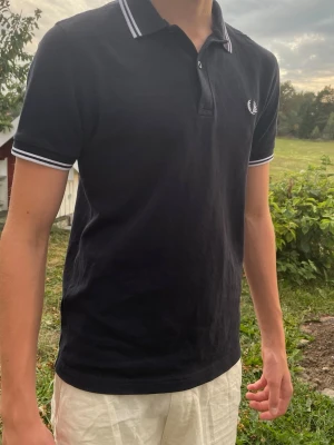  Fred Perry piké  - Svart fred Perry pike storlek Xs har ett litet hål vid axeln men syns inte vid användning kan skicka bild privat .Skriv vid intresse, öppen för bud såklart 😊