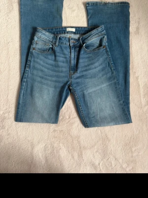 Blå raka jeans Stl 38 Lindex - Säljer ett par klassiska blå jeans med raka ben.  Byxorna har lite skav på baksidan, men det är jättelite.