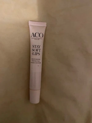 ACO Stay Soft Lips läppbalsam - ACO Stay Soft Lips är ett återfuktande och skyddande läppbalsam i tub med gloss och shimmer. Tuben är ljusrosa och smidig att ha med sig. Perfekt för dig som vill ha mjuka och glansiga läppar med en touch av skimmer.
