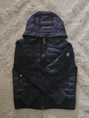 Moncler Cardigan - Detta är en sjukt schysst Moncler Cardigan i storlek S. Säljes då den inte riktigt passade min stil. Plagget är i toppen-skick och har använts varsamt. Nacklappen sitter lite löst, men är självklart inget som påverkar plaggets helhetsintryck. Definitivt ett köp för dig med stil! Bara att skriva om du har frågor eller funderingar!