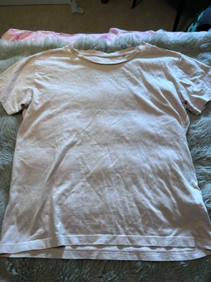 Ljusrosa basic t-shirt - En enkel ljusrosa t-shirt i klassisk modell med rund hals och korta ärmar. Tillverkad i mjukt bomullstyg som känns skönt mot huden. Perfekt att matcha med jeans eller shorts för en avslappnad look.