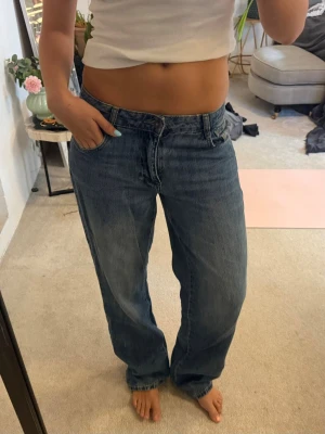 Blå baggy jeans med raka ben - Säljer ett par blå baggy jeans med raka ben och hög midja. Jeansen har klassiska fem fickor och en avslappnad passform som ger en cool och trendig look. Perfekta för dig som gillar en loose fit och vill ha en avslappnad stil. Köpte för 750 kr
