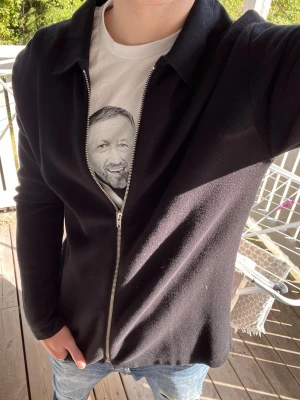 Premium Stickad Zip-Kofta - Snygg och stilren stickad kofta i en svart färg. Koftan har en klassisk krage och dragkedja framtill, vilket ger den en enkel men exklusiv look. Passar perfekt till både jeans, chinos eller kostymbyxor och fungerar lika bra till vardags som till en finare outfit.