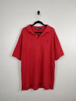 Vintage Polo Ralph Lauren Piké XL Röd Faded Polo Pony Herr Y2K 90sVintage Polo Ralph Lauren Piké XL Röd Faded Polo Pony Herr Y2K 90s - • Storlek: XL • Färg: Röd  • Passform: Relaxed Fit  • Krage: Klassisk pikékrage • Material: 100% bomull  Skick: Plagget är i väldigt fint skick. Eventuella anmärkningar anges alltid tydligt i beskrivningen och visas på bilderna.  Nypris: Cirka 1 600 kr.  📦 Skickas snabbt och packas omsorgsfullt. 💬 Hör gärna av dig om du har frågor eller vill se fler bilder. 🤝 Samfrakt erbjuds vid köp av flera plagg – kika gärna in mina andra annonser!• Storlek: XL • Färg: Röd  • Passform: Relaxed Fit  • Krage: K