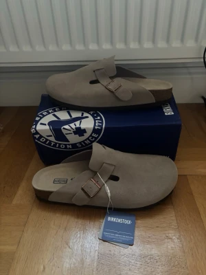 Beige/grå Birkenstock boston - Hej 👋 jag säljer dessa feta birkenstock boston i storlek 43. De är gråa, men åt det beiga hålet skulle jag säga. Helt nya och box samt dustbags ingår. Alltid frakt samma dag‼️