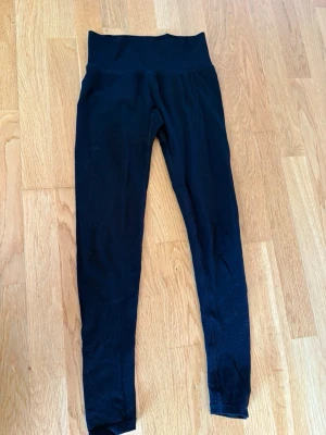 Svarta leggings  - Säljer ett par svarta seamless leggings med scrunch. De är stretchiga och sitter tight, perfekta för träning eller chill. Materialet är mjukt och följsamt, utan synliga sömmar på sidorna. Passar dig som gillar en clean och enkel look. 