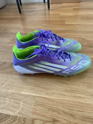 Lila och limegröna fotbollsskor f50  - Säljer ett par f50s cirka 1 månad användning man får extra sulor me på köpet 